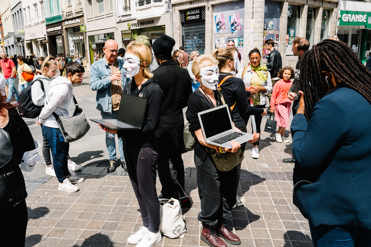 Deux personnes rue de Béthune restent statiques et portent un masque et un ordinateur portable avec leurs mains