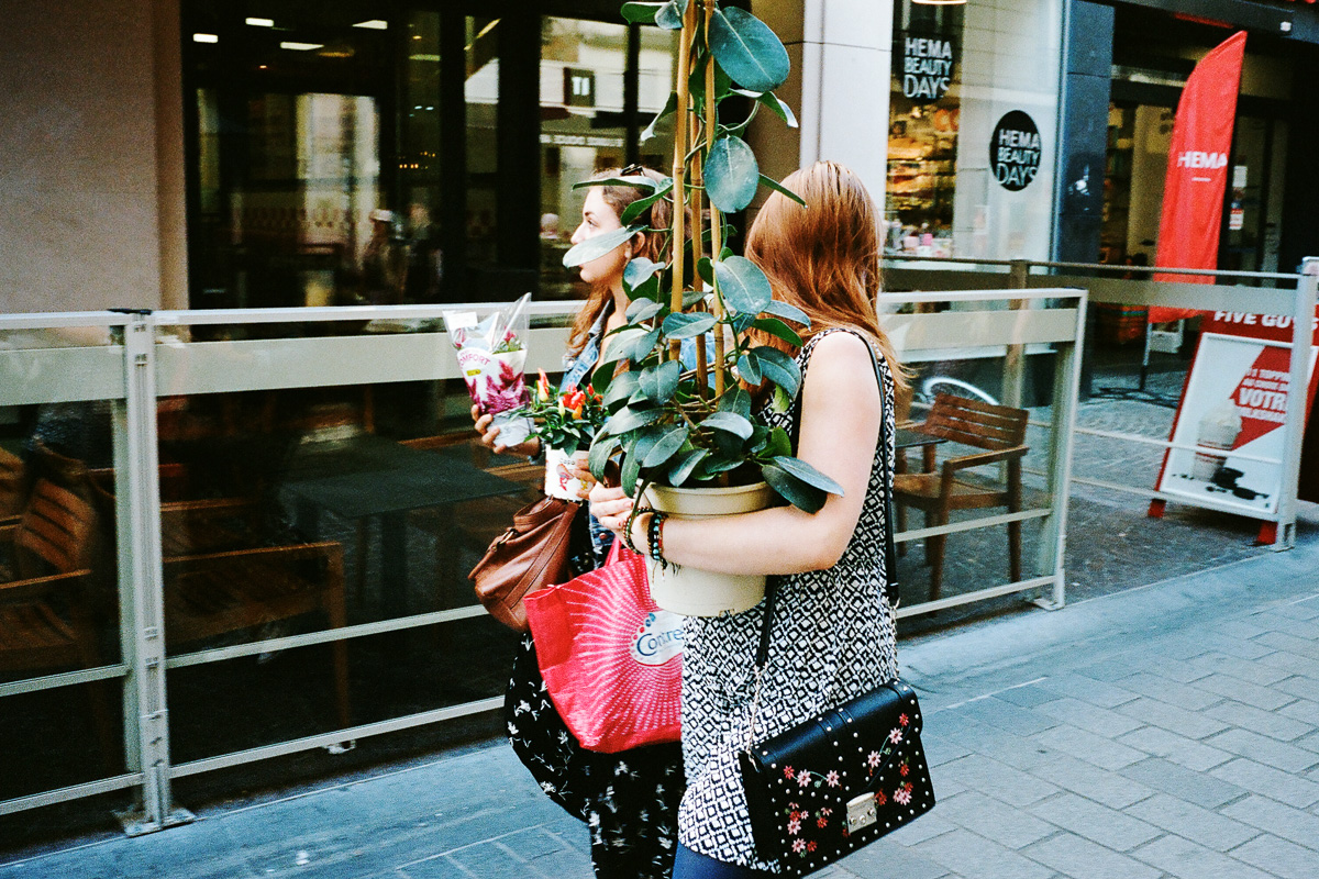 Deux jeunes femmes remontent la rue de Béthune avec des plantes dans les bras