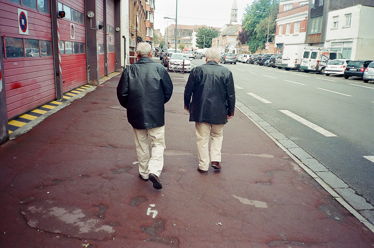 Deux hommes marchent vers le marché de Wazemmes et passent devant une caserne de pompier