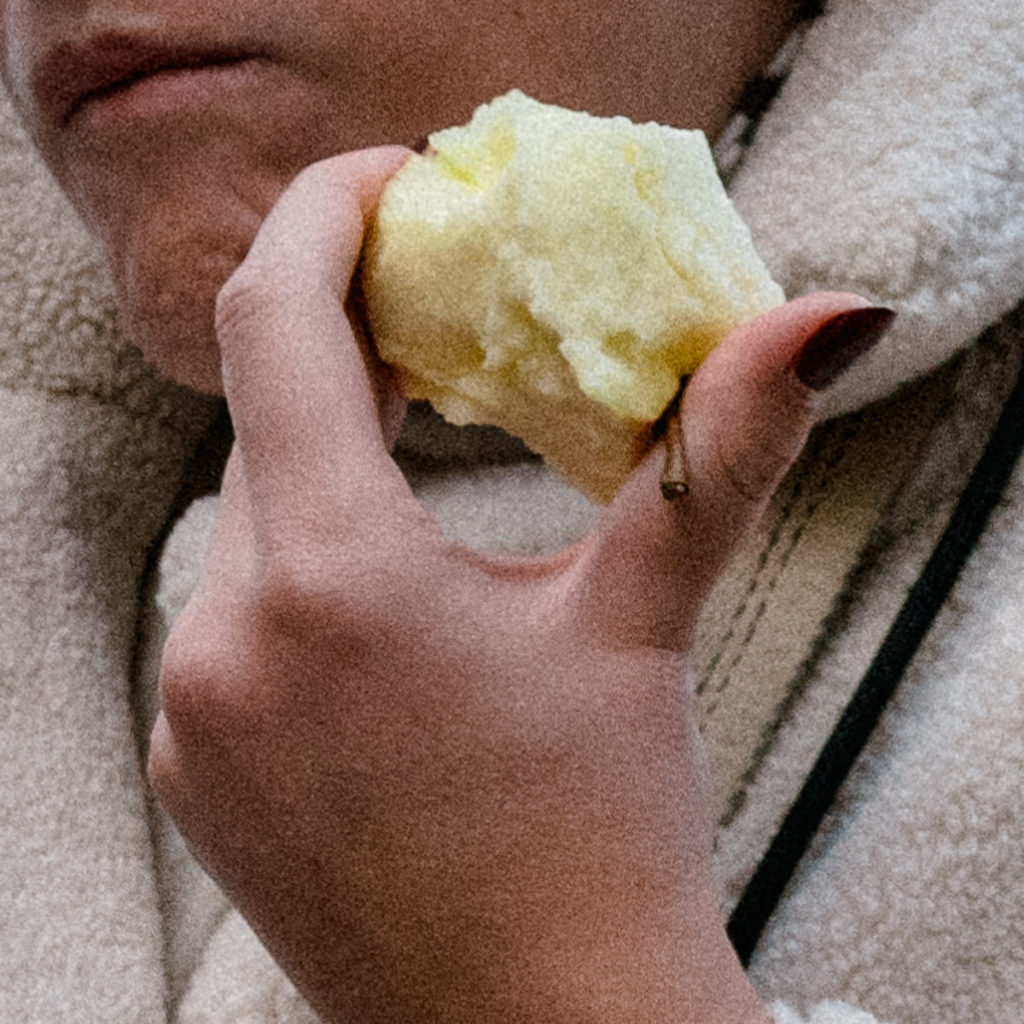 Photographie de rue isolant une main tenant une pomme.