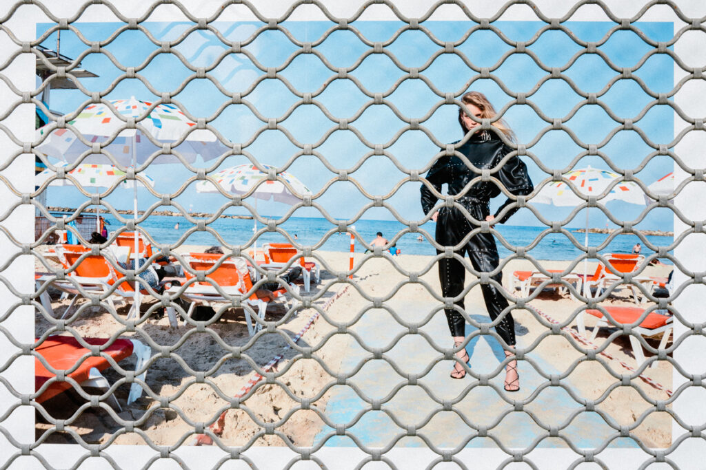 Image publicitaire capturée à travers un rideau métallique, partiellement filtrée par les mailles.